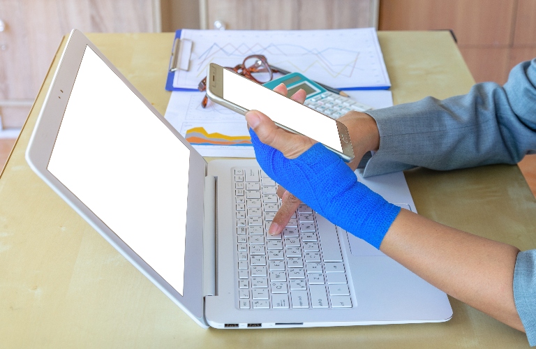 woman with injured hand is using laptop