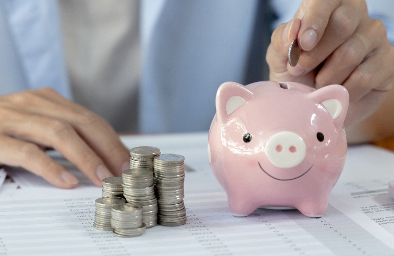 Man puts coins in a piggy bank