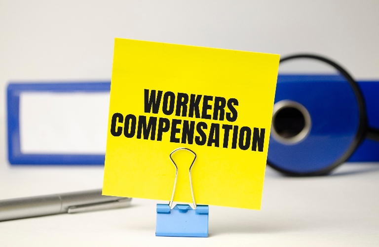 Workers compensation on yellow sticker and blue file folder