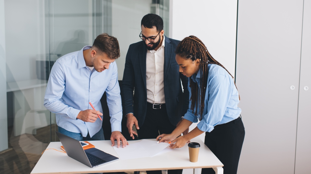 Competitive diverse employers discussing paperwork reports during the meeting